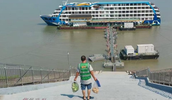 配送人員頂著烈日，無論貨物多少，上坡下坡、穿梭在大街小巷。豐都實業供圖。