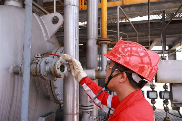 工作人員正在烈日下檢修設備。曾英豪攝