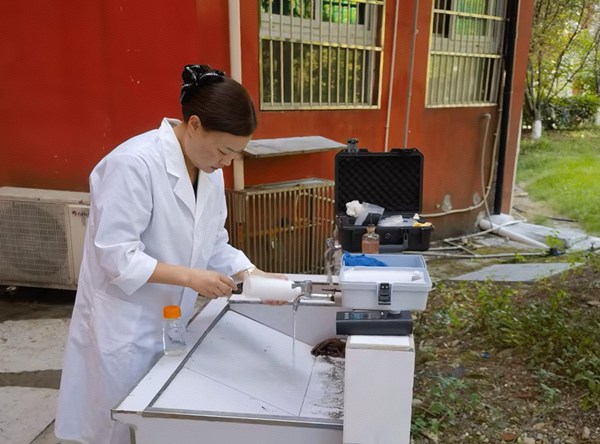 重慶水務集團萬盛供排水公司工作人員取樣檢測校內管網水質。重慶水務集團供圖