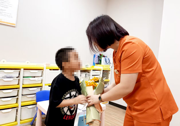孩子給老師送上鮮花。重慶小米熊兒童醫院供圖