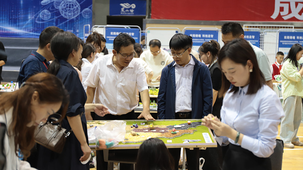 展評活動現場，嘉賓體驗制作區域地圖。重慶市萬盛經開區教育局供圖