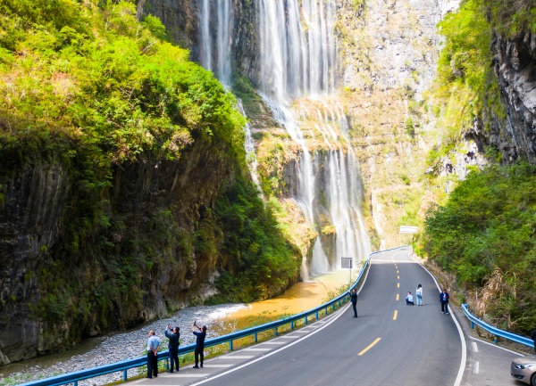 行人駐足觀看飛瀑美景。熊威攝