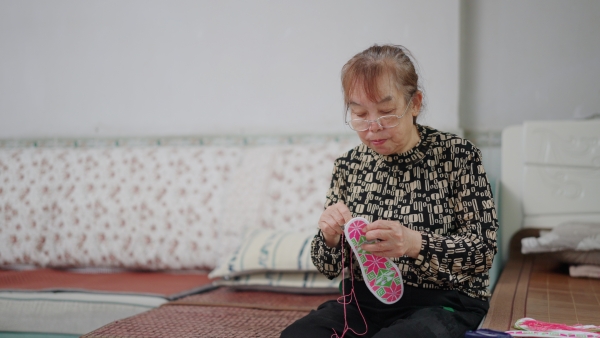 張興會縫制鞋墊。大足區委宣傳部供圖