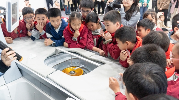 學生觀察海扶刀設備在玻璃片上打字。巴南區融匯小學供圖