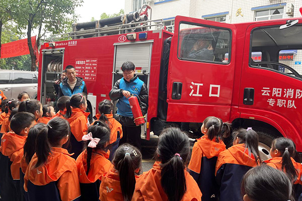 網格員同鎮專職消防員給學生講述消防知識。江口鎮供圖