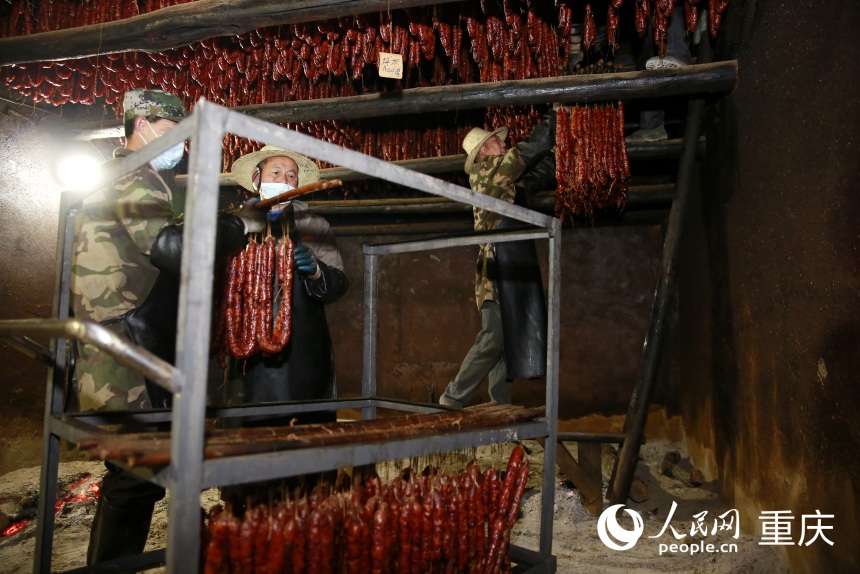 工作人將炕制好的臘味下架取出。人民網記者 劉政寧攝