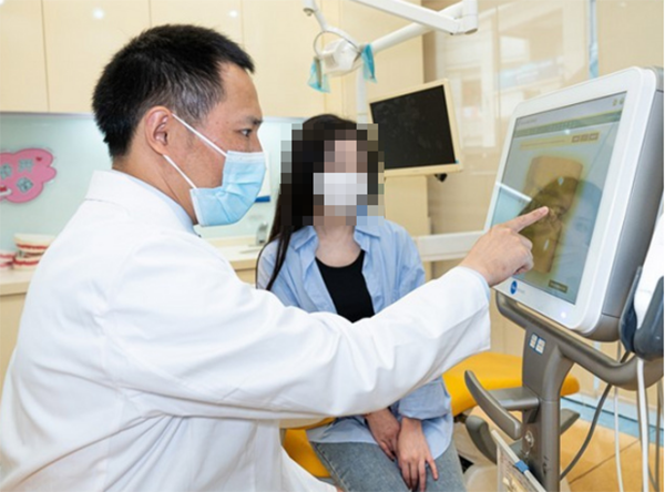 醫生為患者講解牙齒情況。泰康拜博口腔供圖