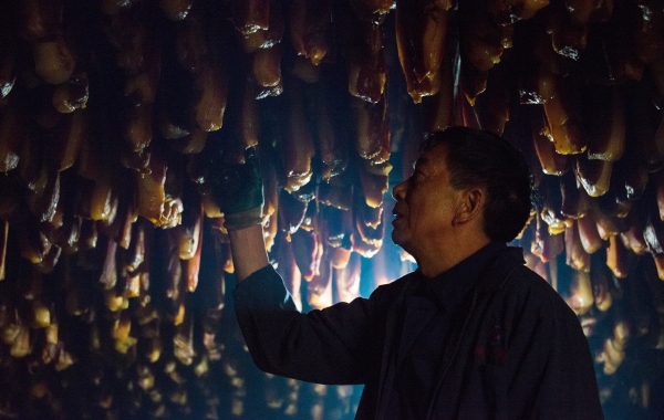 趙孝春在炕房里查看臘肉熏制情況。王雪梅攝