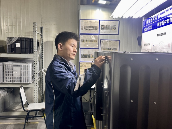 盧躍富測量洗衣機箱體的厚膜。張柳萌攝