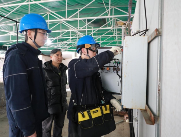 國網重慶綦江供電公司趕水供電所工作人員正在雙豐蘿卜加工廠檢查烘干機控制器指示有無異常。袁巧攝