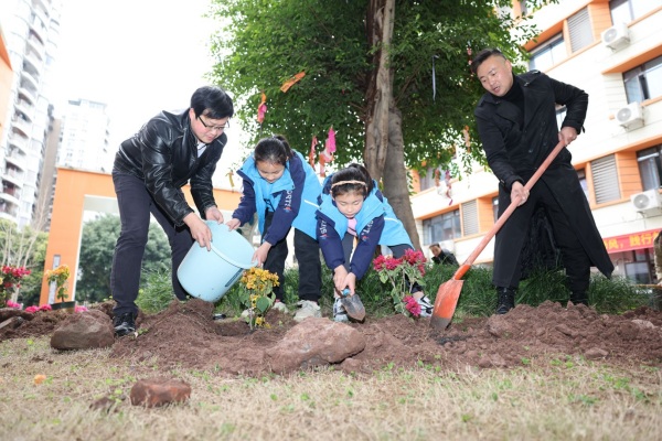 學生和老師、家長攜手植綠，共同美化校園。秦廷富攝