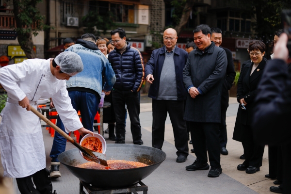 半坡聚落的火鍋店老板現場傳授火鍋炒料技巧。九龍坡區社區教育學院供圖
