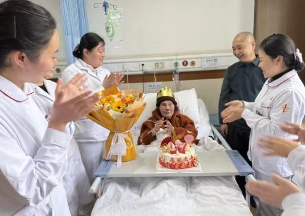 醫護人員與老人一起開心地過百歲生日。巴南區融媒體中心供圖