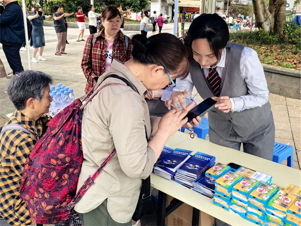 工作人員指導老人使用手機。重慶電信供圖