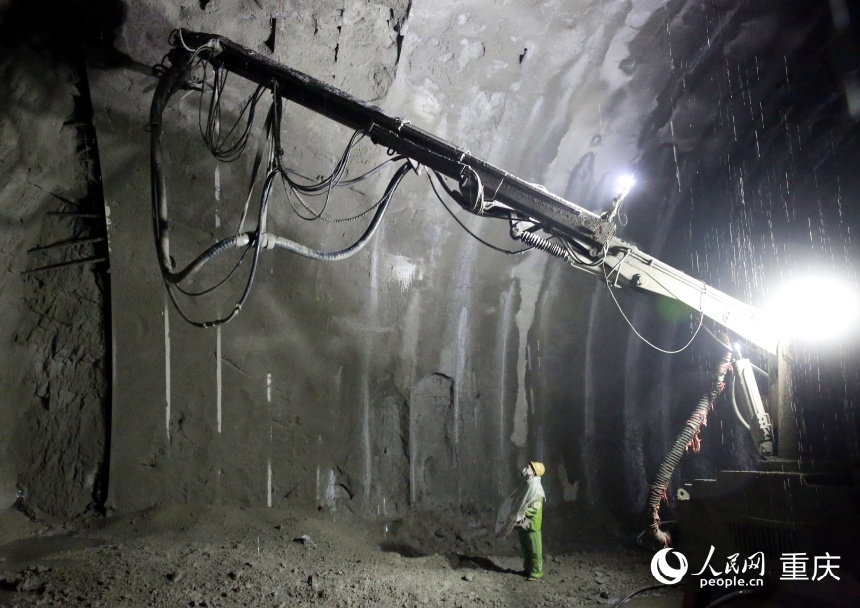施工人員身穿雨衣正在進行噴射混凝土作業。人民網記者 劉政寧攝
