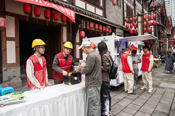 在夏布小鎮，電力志愿者為游客提供免費充電服務。賴小龍攝