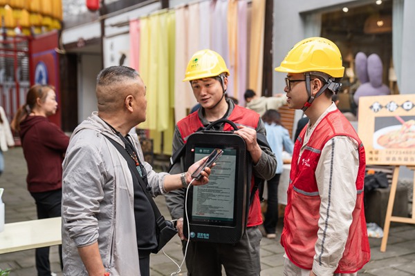 電力志愿者利用移動充電包為游客提供免費充電服務。賴小龍攝
