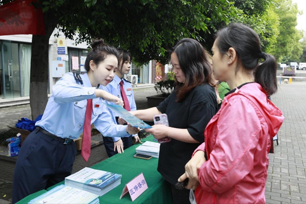在南岸區雞冠石鎮石門社區，稅務部門設置稅費宣傳咨詢服務臺，向居民發放宣傳手冊，解答涉稅疑難問題。蔣宜非攝