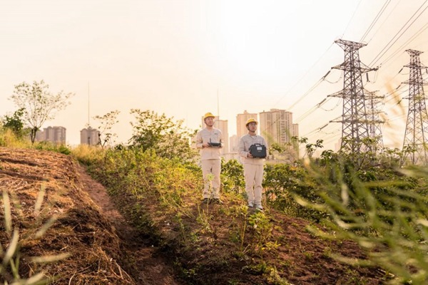 何濤（左一）利用無人機開展巡檢工作。國網重慶永川供電公司供圖