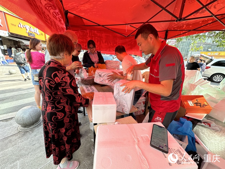 劉琦（右三）在快遞點將鹵鵝打包郵寄。人民網記者 劉政寧攝