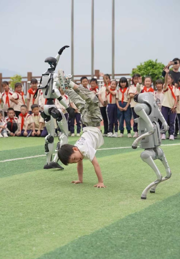 小朋友與機器人“斗舞”。甘國平攝