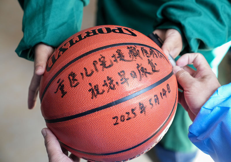 手術后，醫生為洛桑羅布送上籃球。 重慶醫科大學附屬兒童醫院供圖