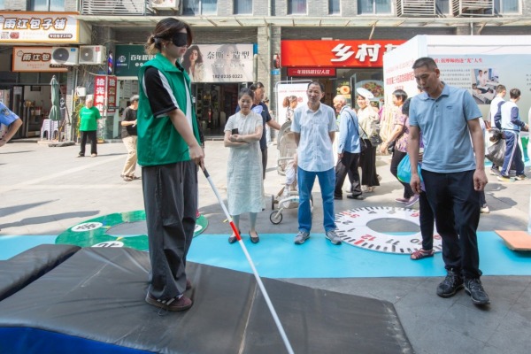 市民戴眼罩沉浸式體驗盲人行走。渝北殘聯供圖
