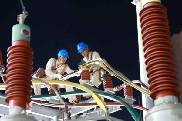 曾光輝（右）和同事開展“零點檢修”，消除設備缺陷 隱患。羅永恒攝