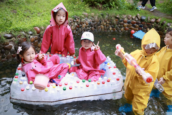 孩子們在自己用廢舊瓶子做的小船上玩得不亦樂乎。唐文蕤攝