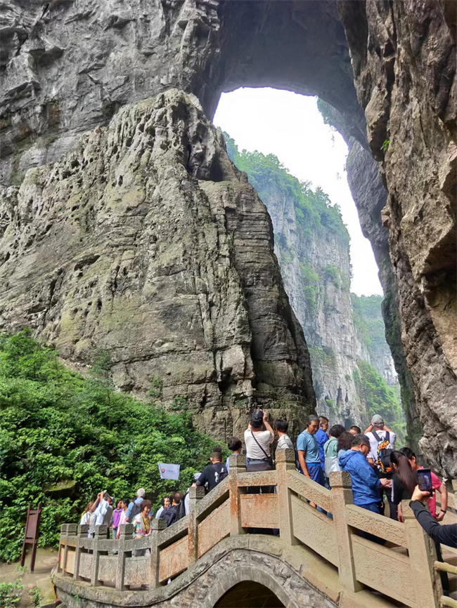 游客在天生三橋攝影留念。武隆喀斯特旅游公司供圖
