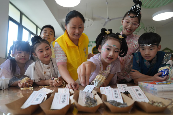 志愿者指導孩子們制作香囊。西南大學供圖