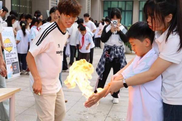 小朋友們在室外廣場體驗“火焰掌”實驗。重慶師范大學供圖