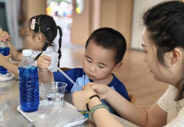 孩子們在老師的指導下做實驗。悅來幼兒園供圖