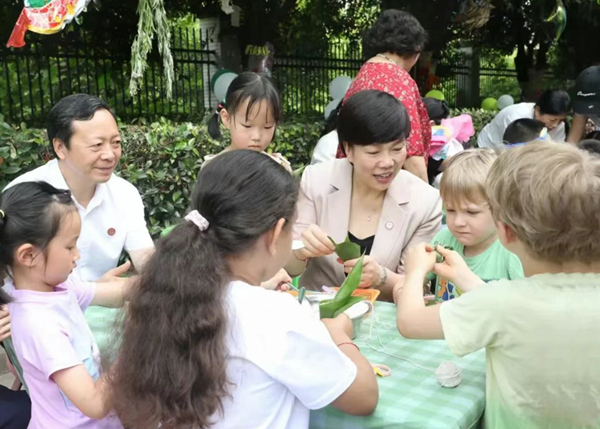 重慶師范大學黨委書記張艷與孩子們一起包粽子。重慶師范大學附屬幼兒園供圖