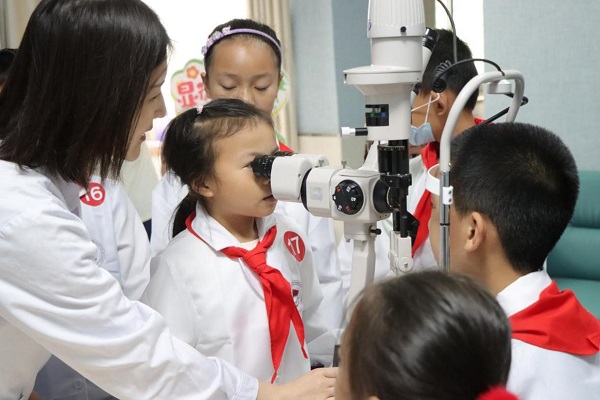 6月7日，“小醫生”們體驗使用眼科裂隙燈。重醫附屬大學城醫院供圖