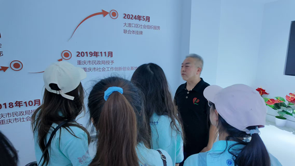 梅明向學生講述梅明社會工作服務中心的發展歷程。重慶理工大學供圖