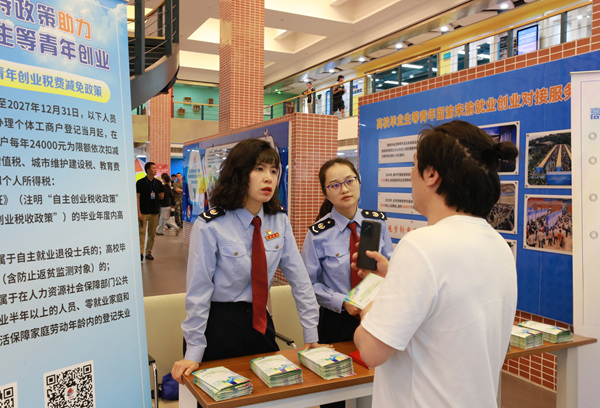 近日，在重慶市大學生就業創業公共服務中心招聘會現場，稅務人員向招聘企業工作人員講解相關稅費政策。覃嫣紅攝