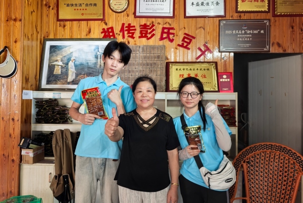 服務隊成員與彭氏豆干傳承人合影。重慶財經學院供圖