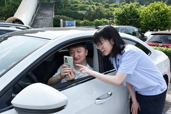 奉節縣稅務人員輔導市民支付停車費后查看發票。蔡仲垚攝