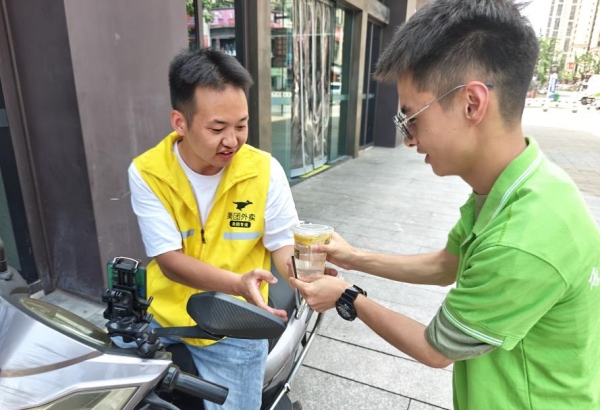 “小電潼”為外賣騎手遞上檸檬水。重慶電力高等?？茖W校供圖