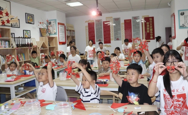 實踐團成員與孩子們共同創作剪紙作品。重慶師范大學美術學院供圖