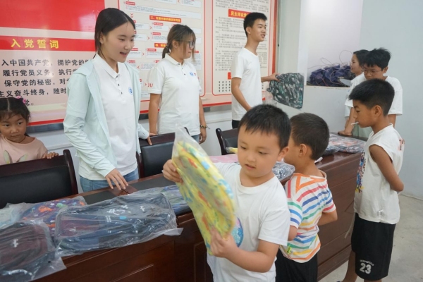 服務團成員給小朋友發放紀念品。李思諺攝