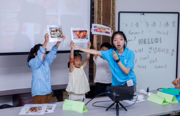 團隊成員通過“蘿卜蹲”游戲為孩子們教授法語單詞。盧力攝