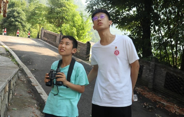 服務團成員帶領小朋友戶外觀鳥。重慶師范大學供圖