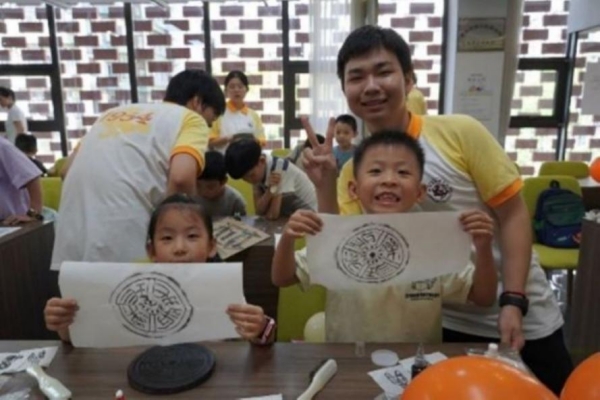 團隊成員指導小朋友體驗拓印。重慶師范大學供圖