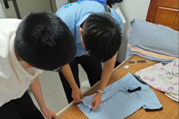 志愿者指導小朋友整理衣物。重慶理工大學供圖