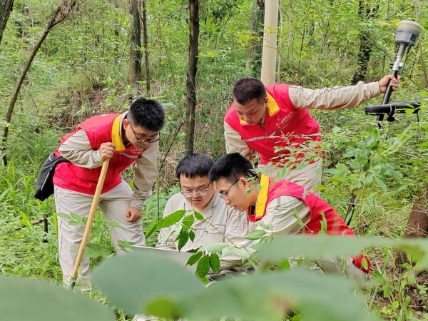 國網重慶經研院設計中心員工在成渝中線高鐵牽引站供電線路勘測現場討論設計方案。程婧雪攝