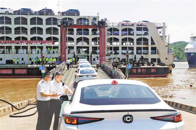 “重慶造”汽車排隊上滾裝船，重慶海關關員開展現場核查。（受訪者供圖）