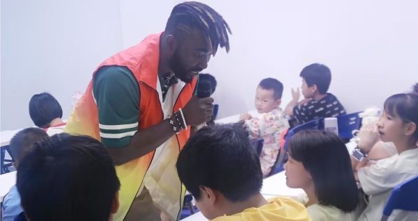 實踐團留學生志愿者用外語與兒童對話。鄭佳欣攝