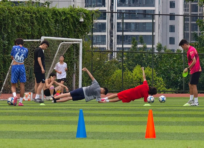 2025年8月8日，江北區石子山體育場，年輕人在操場上訓練足球。記者 崔力 攝